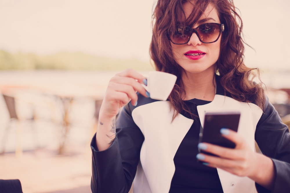 young-woman-drinking-coffee-smartphone