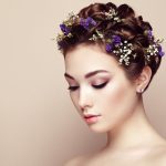 Face of beautiful woman decorated with flowers