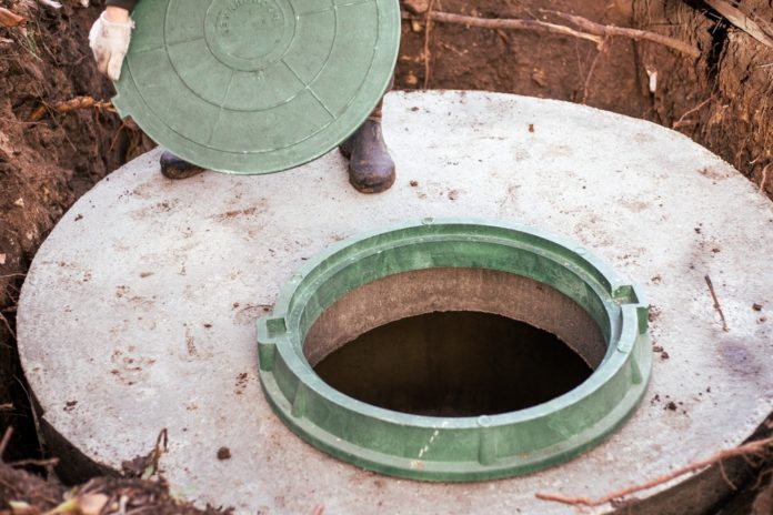 The,Plumber,Covers,The,Sewer,Well,With,A,Manhole,Cover.