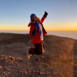 Dr. Michaela Musilova jumping on top of Kilimanjaro