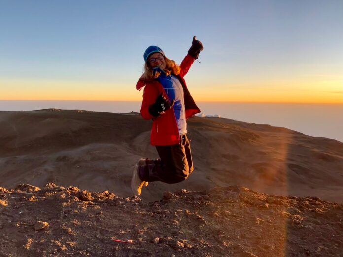 Dr. Michaela Musilova jumping on top of Kilimanjaro